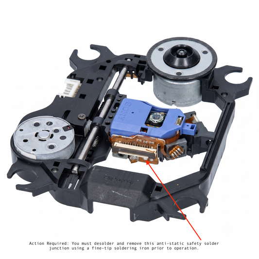 Close-up view of the Sony KHM-313AAA laser mechanism showing the ribbon cable connector and a red arrow pointing to the anti-static safety solder point that must be desoldered before use.