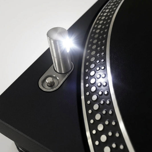 Close-up of an upgraded bright white LED pop-up target light illuminated on a black Technics turntable deck next to the strobe platter.