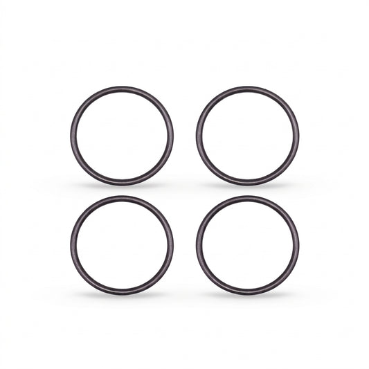 High-resolution, clean studio shot displaying four identical black rubber O-rings arranged in a neat two-by-two grid against a solid white background. Each circular ring features a smooth, rounded profile with subtle metallic or semi-gloss highlights that give them a three-dimensional appearance. Soft, faint shadows are cast directly beneath each ring, grounding them on the surface.