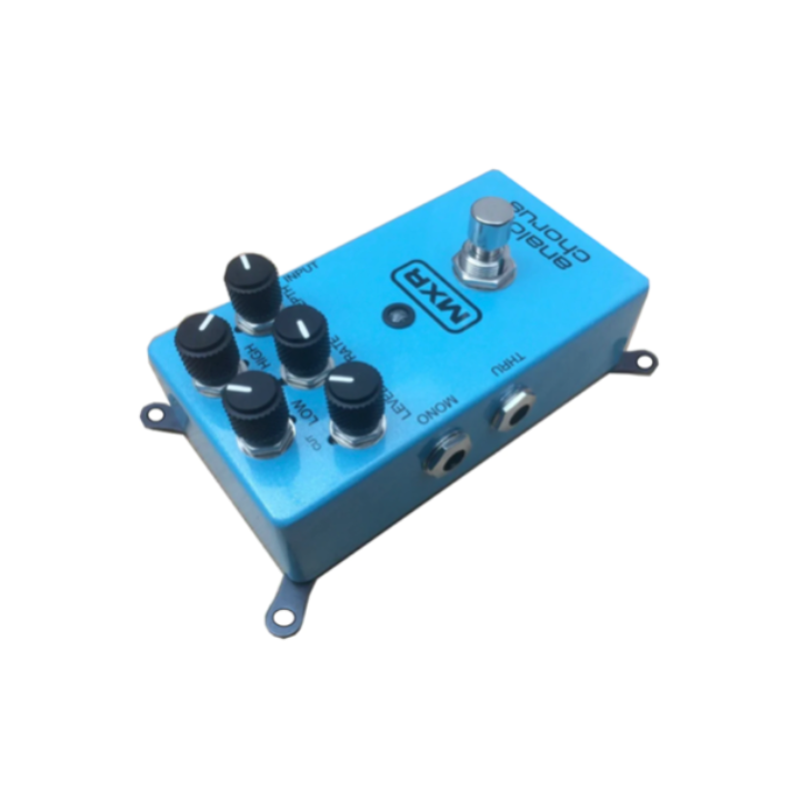 A top-down perspective of a blue MXR Analog Chorus guitar pedal with four black mounting brackets attached to its base corners. The brackets flare outward, showing open holes that allow the pedal to be screwed directly onto a pedalboard for a secure, permanent fit.