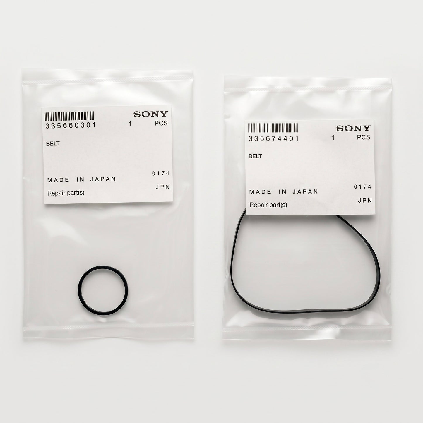 A top-down product photograph shows two separate, transparent plastic parts bags lying side-by-side on a plain white surface. Each bag contains a genuine Sony replacement belt and features an official white paper label stuck to the front.