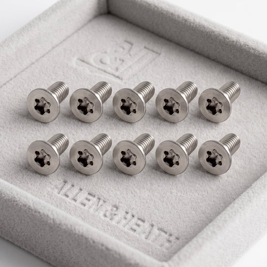 Ten silver Allen & Heath star-drive screws arranged in two rows inside a gray felt jewelry box.