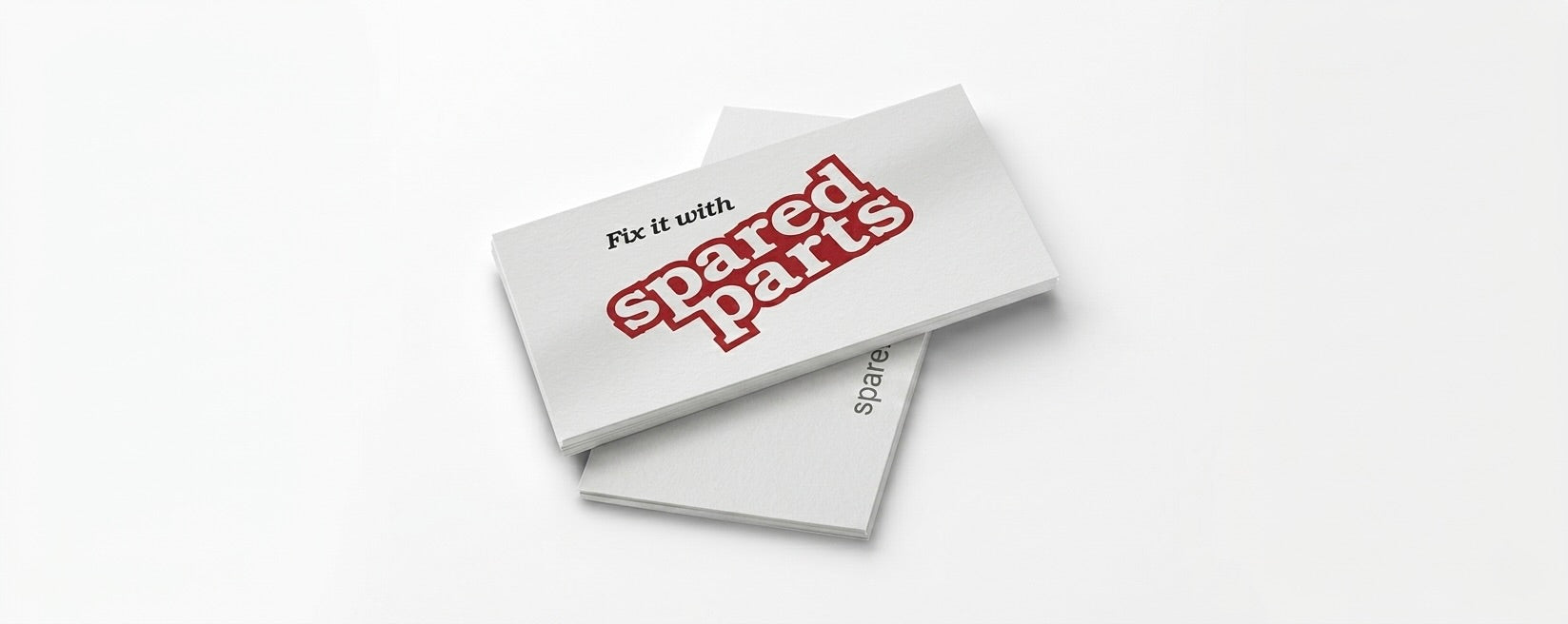 Two white rectangular cards or booklets stacked slightly offset on a light gray background. The top card features the text 'Fix it with' in black above a large red and white 'spared parts' logo.
