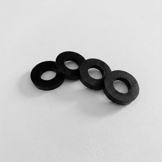 Four black rubber washers on a white background