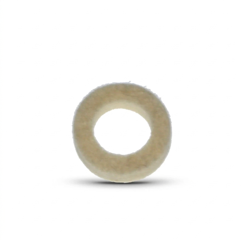 A close-up studio shot of a circular felt washer, viewed from directly above against a plain white background. The washer is thick and ring-shaped, with a fuzzy, textured surface in an off-white or cream colour. A soft, dark shadow is cast beneath it, giving the object a sense of depth.