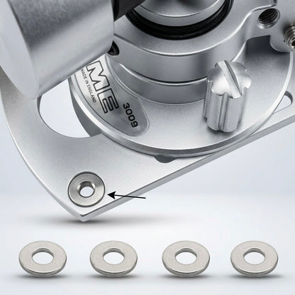 Product diagram of an SME 3009 tonearm bedplate, showing a metallic coloured base with an arrow pointing to a circular recess labeled "Insert Washer x 4". Below the tonearm assembly, a row of four flat, metallic silver washers is displayed side-by-side against a white background with soft drop shadows.
