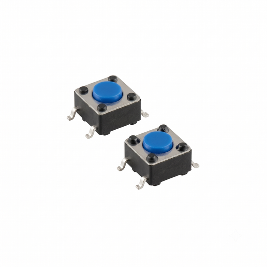 An isolated studio shot of a two-pack of upgraded power switches for a Gtech handheld vacuum, arranged diagonally against a seamless white background. Each component is a small, square tactile micro-switch featuring a black plastic housing body, a metallic silver top plate secured by four tiny rivets, and a vibrant blue circular push-button in the centre. Four gull-wing-shaped metallic solder leads extend from the sides for surface-mount installation.
