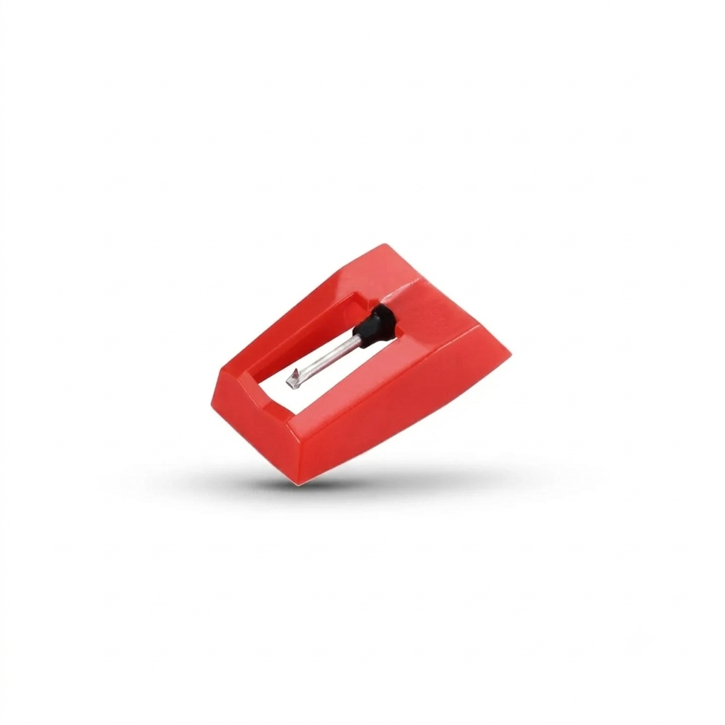 A studio product shot of a bright red plastic turntable stylus (needle) assembly, showing the metal cantilever and diamond tip pointing downward, floating slightly with a soft shadow on a solid white background.