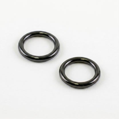 Two glossy, dark black rubber O-rings resting diagonally on a clean, solid white background, showing the shiny surface texture of the Marantz TT-15S1 turntable counterweight seals.