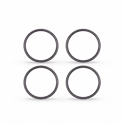 igh-resolution, clean studio shot displaying four identical black rubber O-rings arranged in a neat two-by-two grid against a solid white background. Each circular ring features a smooth, rounded profile with subtle metallic or semi-gloss highlights that give them a three-dimensional appearance. Soft, faint shadows are cast directly beneath each ring, grounding them on the surface.