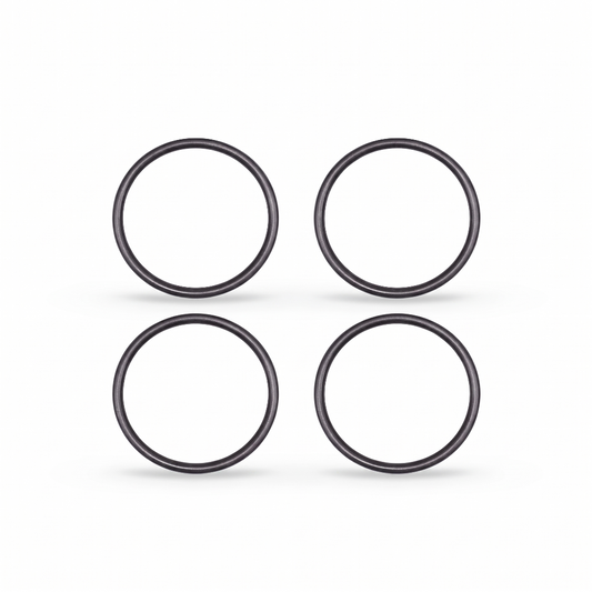 igh-resolution, clean studio shot displaying four identical black rubber O-rings arranged in a neat two-by-two grid against a solid white background. Each circular ring features a smooth, rounded profile with subtle metallic or semi-gloss highlights that give them a three-dimensional appearance. Soft, faint shadows are cast directly beneath each ring, grounding them on the surface.