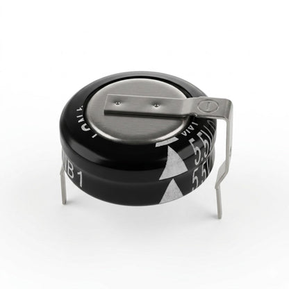 A studio product shot of a Panasonic horizontal SD series super capacitor against a plain white background. The coin-cell type electronic component has a black cylindrical body with a metallic top surface. A bent metal terminal is spot-welded across the top and extends downward on the right side, while another terminal pins downward on the left for through-hole mounting. White markings on the black casing indicate technical specifications, including "5.5V" and white arrow symbols.