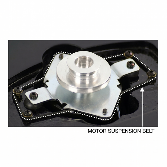 Close-up diagram showing the inner mechanism of a Pro-Ject turntable motor assembly. A silver aluminum pulley sits in the center of a metallic mounting plate, secured over a black cutout housing. A white dotted line highlights the path of the black rubber motor suspension belt as it stretches around four perimeter screws to isolate the motor. A white arrow in the bottom right points directly to the belt, labeled with the text "MOTOR SUSPENSION BELT".