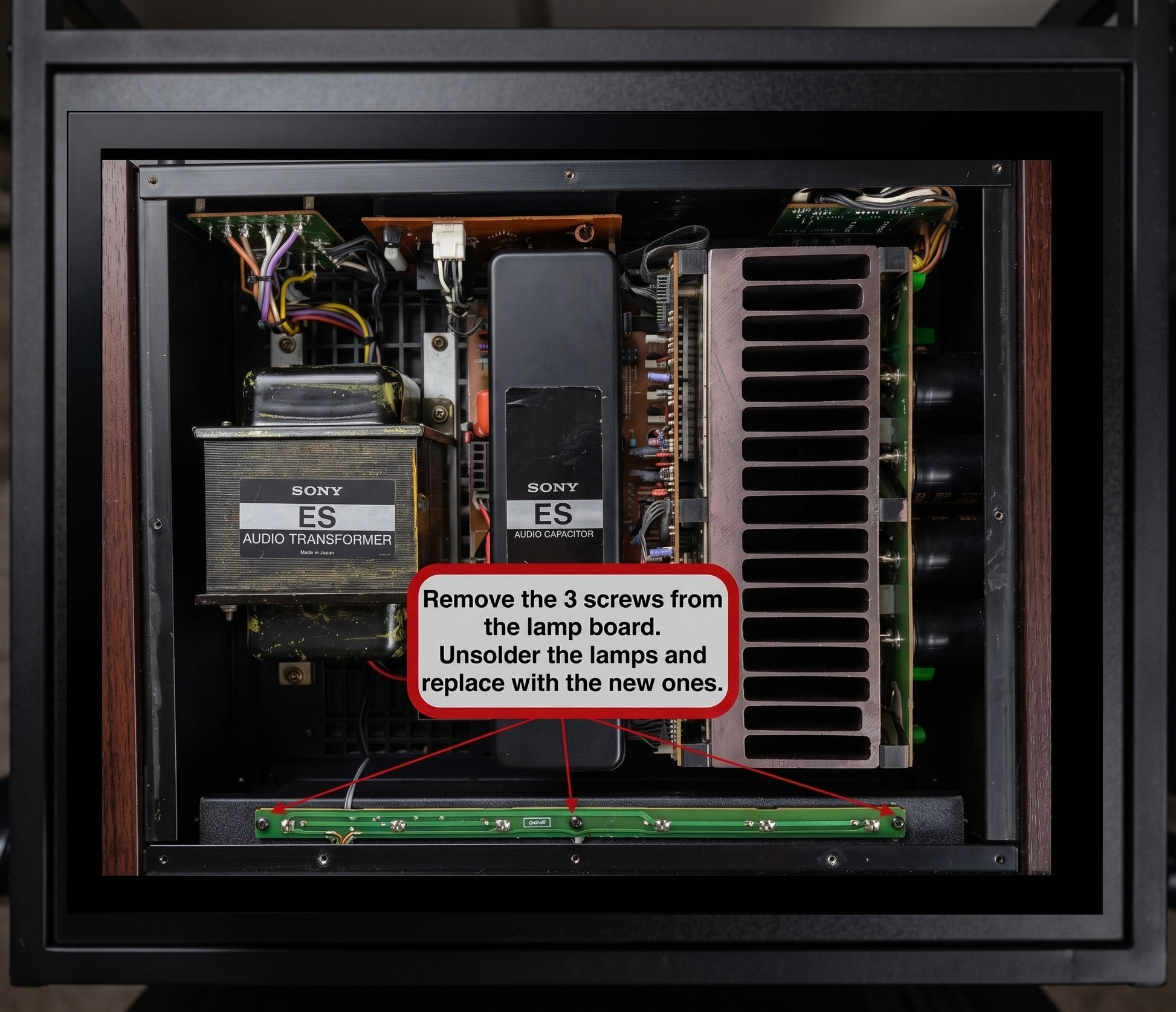 Top-down view of an open electronic amplifier or speaker cabinet interior, showing internal components including a large silver heatsink, transformers, circuit boards, and a green circuit board at the bottom. A red text box with instructions reads: 'Remove the 3 screws from the lamp board.