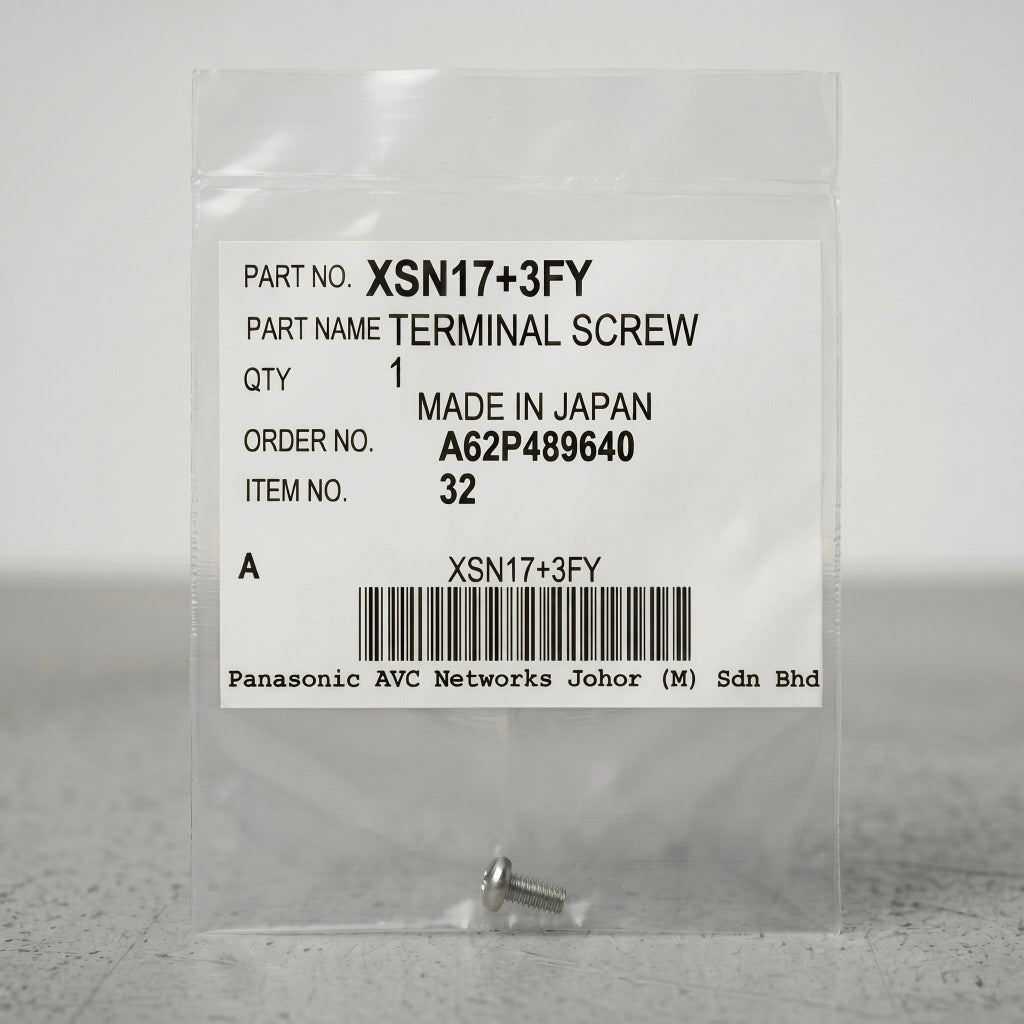A small, silver terminal screw sits at the bottom of a clear, sealed plastic packet against a neutral gray background. The center of the packet features a prominent white product label containing text details and a barcode. The label reads: "PART NO. XSN17+3FY", "PART NAME TERMINAL SCREW", "QTY 1", "MADE IN JAPAN", "ORDER NO. A62P489640", and "ITEM NO. 32". A barcode is centered near the bottom of the label, with "Panasonic AVC Networks Johor (M) Sdn Bhd" printed in a monospace font underneath.