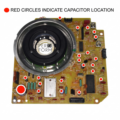 A printed circuit board component with a large circular black and silver motor or speaker-like element, many small red indicator circles, and printed text at the top reading 'RED CIRCLES INDICATE CAPACITOR LOCATION'. 