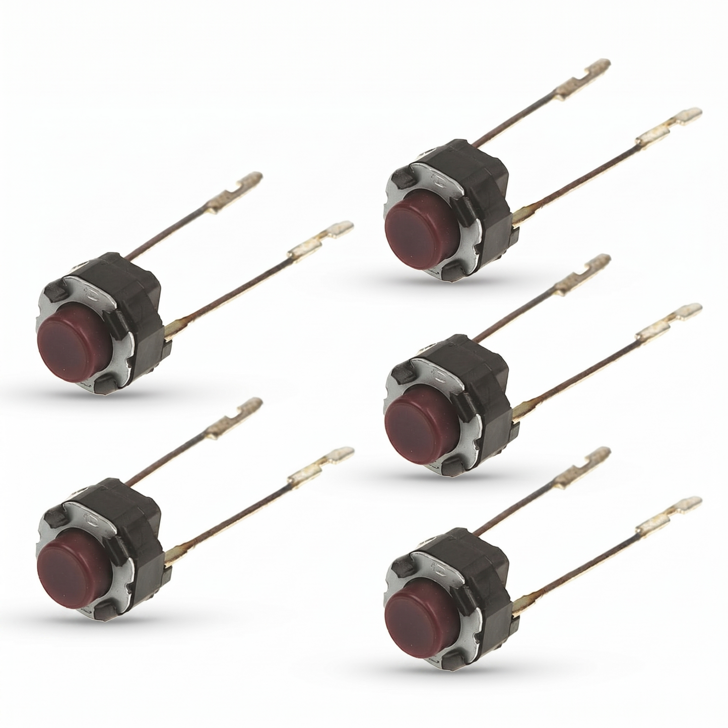 Clean studio shot against a seamless white background showing five identical electronic component switches arranged in two vertical rows. Each component is a small tactile switch featuring a circular, dark red or maroon button plunger housed in a black and silver metal casing. Extending from the rear of each switch are two long, thin metallic solder terminals with notched tips, casting soft drop shadows beneath them.