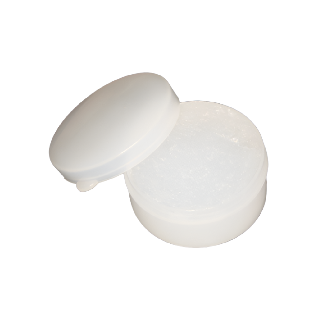 A small, round, white plastic container filled with thick, clear, semi-transparent grease. The container is viewed from a slightly elevated angle. Its white plastic lid is propped open and resting at an angle on the left rim of the jar, revealing a tab on its edge. The background is isolated on pure white, and the lighting casts subtle shadows underneath the container and lid.