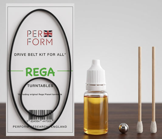 A drive belt kit for all Rega turntables by Perform, shown with its white retail box, a small bottle of amber liquid, a metal ball, and two wooden-handled tools on a dark tabletop against a light gray background.