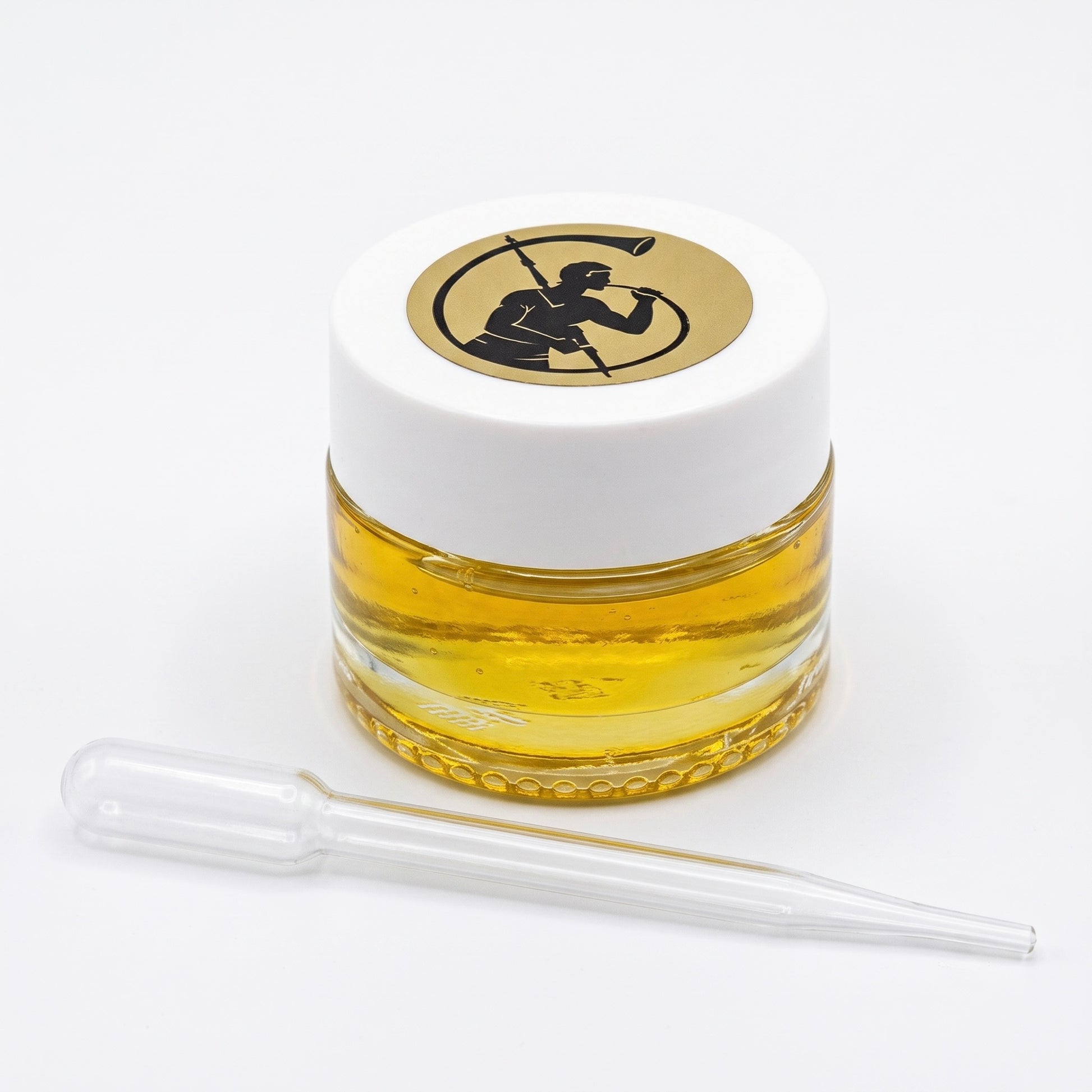 A small, clear glass jar filled with golden yellow liquid, topped with a white lid featuring a circular black-and-gold logo, with a clear glass pipette placed in front on a white background.