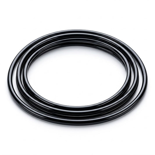 A high-resolution photograph of a glossy, jet-black round turntable drive belt, neatly coiled into multiple concentric loops. The belt rests flat against a clean, seamless bright white background, casting a soft, subtle shadow beneath it.