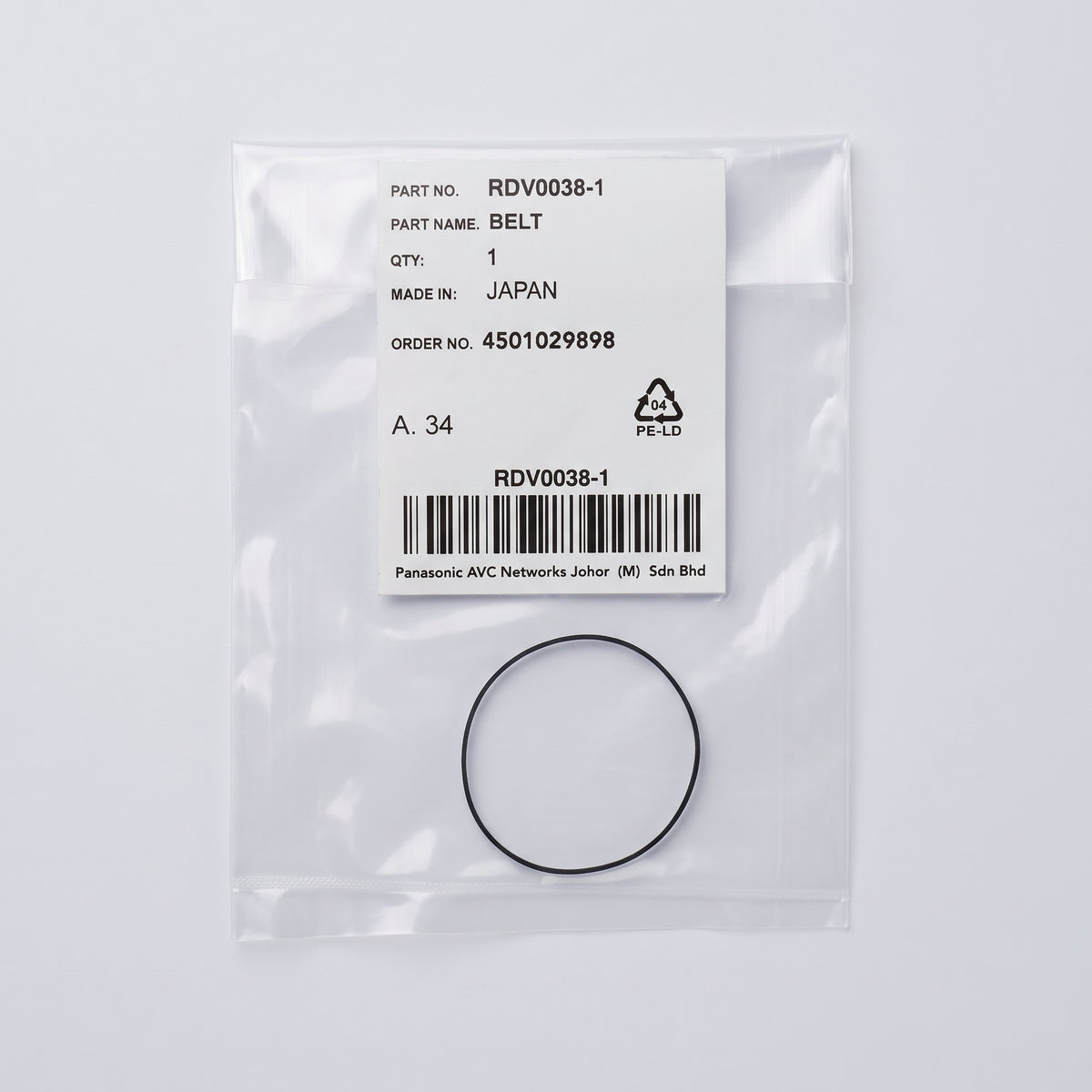 A black rubber belt packaged in a clear plastic bag with a white label. The label shows the part number RDV0038-1, part name BELT, made in JAPAN, and a barcode.