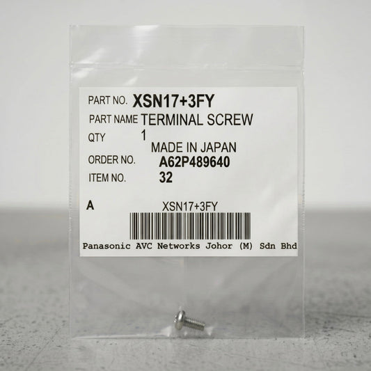 A small, silver terminal screw sits at the bottom of a clear, sealed plastic packet against a neutral gray background. The center of the packet features a prominent white product label containing text details and a barcode. The label reads: "PART NO. XSN17+3FY", "PART NAME TERMINAL SCREW", "QTY 1", "MADE IN JAPAN", "ORDER NO. A62P489640", and "ITEM NO. 32". A barcode is centered near the bottom of the label, with "Panasonic AVC Networks Johor (M) Sdn Bhd" printed in a monospace font underneath.