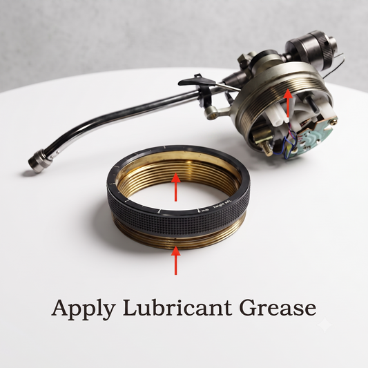 A close-up of a metal mechanical component and a black threaded ring with red arrows pointing to greased areas, plus the text 'Apply Lubricant Grease' on a white surface.